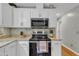 Kitchen features granite countertops, mosaic backsplash, and stainless steel appliances, including a range and microwave at 6828 Edwell Ct, Raleigh, NC 27617