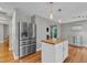 Bright kitchen boasts stainless steel appliances, a wood-top island with modern pendant lighting, and hardwood floors at 6828 Edwell Ct, Raleigh, NC 27617