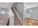 Staircase leading to an open dining area with hardwood floors and a modern glass table set at 6828 Edwell Ct, Raleigh, NC 27617