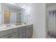 Clean bathroom with double sinks, modern fixtures, and a shower-tub combo with decorative curtain at 71 Sandy Farm Ct, Willow Springs, NC 27592