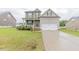 Charming two-story home with a well-manicured lawn, inviting front porch, and attached garage at 71 Sandy Farm Ct, Willow Springs, NC 27592