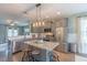 Open kitchen boasts stainless appliances, granite counters, island with seating, and stylish pendant lighting at 71 Sandy Farm Ct, Willow Springs, NC 27592
