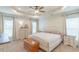 The main bedroom boasts a tray ceiling, carpeted floors, and large windows at 71 Sandy Farm Ct, Willow Springs, NC 27592