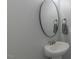 Elegant powder room features a pedestal sink, oval mirror, and stylish faucet at 71 Sandy Farm Ct, Willow Springs, NC 27592