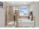 Bright bathroom featuring a tiled walk-in shower and separate soaking tub under a window at 7584 Oakberry Dr, Raleigh, NC 27616