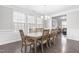Bright dining room featuring a large table, hardwood floors, and views into the living room at 7584 Oakberry Dr, Raleigh, NC 27616