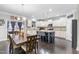 Open kitchen boasts white cabinets, large island with seating, and a rustic wood dining table, creating an inviting space at 7584 Oakberry Dr, Raleigh, NC 27616