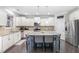 Bright kitchen featuring white cabinets, stainless steel appliances, granite counters, and island with seating at 7584 Oakberry Dr, Raleigh, NC 27616