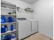 Laundry room with shelving, stocked with supplies, and a modern washer and dryer at 7584 Oakberry Dr, Raleigh, NC 27616