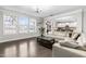 Bright living room with large windows, hardwood floors, and a comfortable white sofa at 7584 Oakberry Dr, Raleigh, NC 27616