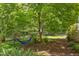 Secluded backyard with hammock, lush greenery, shade trees, and landscaped garden bed, perfect for relaxation at 800 E Forest Hills Blvd, Durham, NC 27707