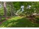 Spacious backyard with lush green lawn and mature trees, perfect for outdoor activities at 800 E Forest Hills Blvd, Durham, NC 27707