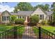 Charming single-story home with manicured lawn, black fence and a welcoming front porch and mature landscaping at 800 E Forest Hills Blvd, Durham, NC 27707