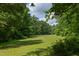 Expansive green space surrounded by mature trees, offering a serene and natural setting at 800 E Forest Hills Blvd, Durham, NC 27707