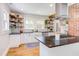 Bright, updated kitchen featuring white subway tile, open shelves, stainless steel appliances, and dark countertops at 800 E Forest Hills Blvd, Durham, NC 27707