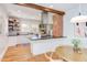 Spacious kitchen with a brick accent wall, open shelving, stainless steel appliances, and a breakfast bar at 800 E Forest Hills Blvd, Durham, NC 27707