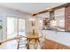 Bright kitchen with a breakfast nook features a wooden beam, brick accents, and a sliding door to outdoor living at 800 E Forest Hills Blvd, Durham, NC 27707