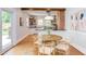 Modern eat-in kitchen with a wooden beam, brick accent wall, open shelving, and a stylish round dining table at 800 E Forest Hills Blvd, Durham, NC 27707