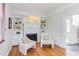 Bright living room featuring a white fireplace flanked by built-in bookshelves and two chairs on hardwood floors at 800 E Forest Hills Blvd, Durham, NC 27707