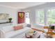 Inviting living room featuring a neutral color palette, white sofa, and charming red door with wreath at 800 E Forest Hills Blvd, Durham, NC 27707