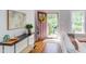 Stylish living room entrance featuring hardwood floors, a console table, and an open door with view of backyard at 800 E Forest Hills Blvd, Durham, NC 27707