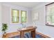 Well-lit office space featuring stained glass windows, a wooden desk, and a blue rug over hardwood floors at 800 E Forest Hills Blvd, Durham, NC 27707