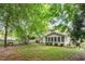Back exterior featuring a screened-in sunroom and a well-maintained backyard with lush greenery and mature trees at 825 Federal House Ave, Wake Forest, NC 27587