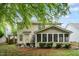 Two-story home featuring a screened-in sunroom and a well-maintained backyard with lush greenery and mature trees at 825 Federal House Ave, Wake Forest, NC 27587