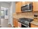 A well-equipped kitchen featuring stainless steel appliances, wooden cabinets, and stone countertops at 825 Federal House Ave, Wake Forest, NC 27587