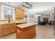 Bright kitchen featuring wood cabinets, granite countertops and stainless steel appliances, seamlessly flowing into the living room at 825 Federal House Ave, Wake Forest, NC 27587