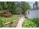 Beautiful backyard with lush greenery, a stone patio, and a pergola-covered seating area at 8420 Caldbeck Dr, Raleigh, NC 27615