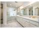 Bright bathroom features double sinks, white cabinets, and glass enclosed shower at 8420 Caldbeck Dr, Raleigh, NC 27615