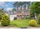 Charming two-story brick home with a well-manicured lawn and mature trees at 8420 Caldbeck Dr, Raleigh, NC 27615