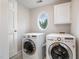Convenient laundry room with a washer, dryer, and storage cabinets with a unique window at 8420 Caldbeck Dr, Raleigh, NC 27615