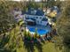 Aerial view of home's backyard with a beautiful in-ground pool, patio, mature trees, and lush landscaping at 8709 Kimalden Ct, Wake Forest, NC 27587