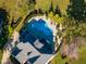 Overhead view of a home's backyard featuring a uniquely shaped pool with adjacent patio and lush, green surroundings at 8709 Kimalden Ct, Wake Forest, NC 27587