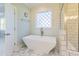 Beautiful bathroom features a soaking tub beneath a patterned window and a glass shower with white subway tiles at 8709 Kimalden Ct, Wake Forest, NC 27587