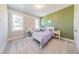 A bedroom with a pale green wall, and two bright windows, plus desk, shelving and plush carpet at 8709 Kimalden Ct, Wake Forest, NC 27587
