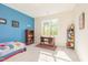 Bright bedroom with one blue accent wall, complemented by modern trim and a sunlit window at 8709 Kimalden Ct, Wake Forest, NC 27587