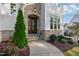 View of front door with stone archway, sidelights and covered porch, framed by manicured landscaping at 8709 Kimalden Ct, Wake Forest, NC 27587