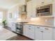 Well-equipped kitchen featuring stainless steel appliances, white cabinets, and light granite countertops at 8709 Kimalden Ct, Wake Forest, NC 27587