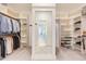 Spacious walk-in closet with ample shelving and a large mirror reflecting the hallway of the home at 8709 Kimalden Ct, Wake Forest, NC 27587