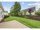 Fenced backyard with a well-manicured lawn, patio, and mature landscaping at 923 Peltier Dr, Cary, NC 27519