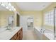 A bright primary bathroom features a soaking tub, double sink vanity, and walk-in closet at 923 Peltier Dr, Cary, NC 27519
