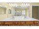 Bathroom with a double sink vanity, warm lighting, and neutral colored walls at 923 Peltier Dr, Cary, NC 27519