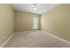 An empty carpeted bedroom with neutral colored walls and ceiling fan at 923 Peltier Dr, Cary, NC 27519