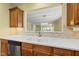 Kitchen sink under window into the dining area with stainless steel appliances and wood cabinets at 923 Peltier Dr, Cary, NC 27519