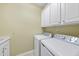 Clean laundry room with white appliances and cabinetry at 923 Peltier Dr, Cary, NC 27519