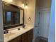 Bathroom with a double sink vanity, large framed mirror, and a glass enclosed shower at 929 Sagamore Dr, Louisburg, NC 27549