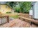 Backyard featuring a deck, a bench, stone landscaping, and a partial view of a yellow home at 100 Longneedle Ct, Raleigh, NC 27603